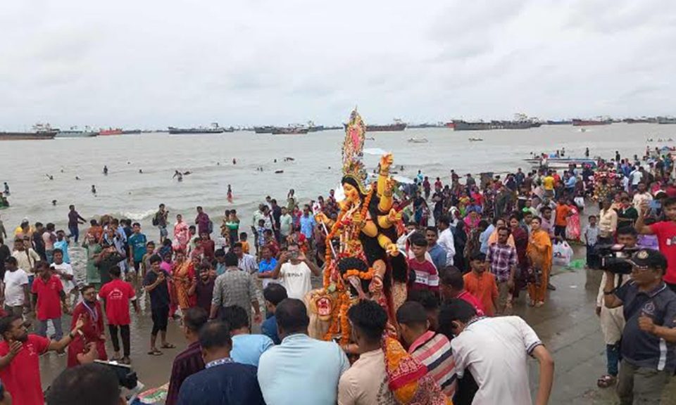 বৈরী আবহাওয়ার মধ্যেও বিসর্জন দেখতে পতেঙ্গা সমুদ্রসৈকতে মানুষের ঢল নামে। ছবি : বাসস