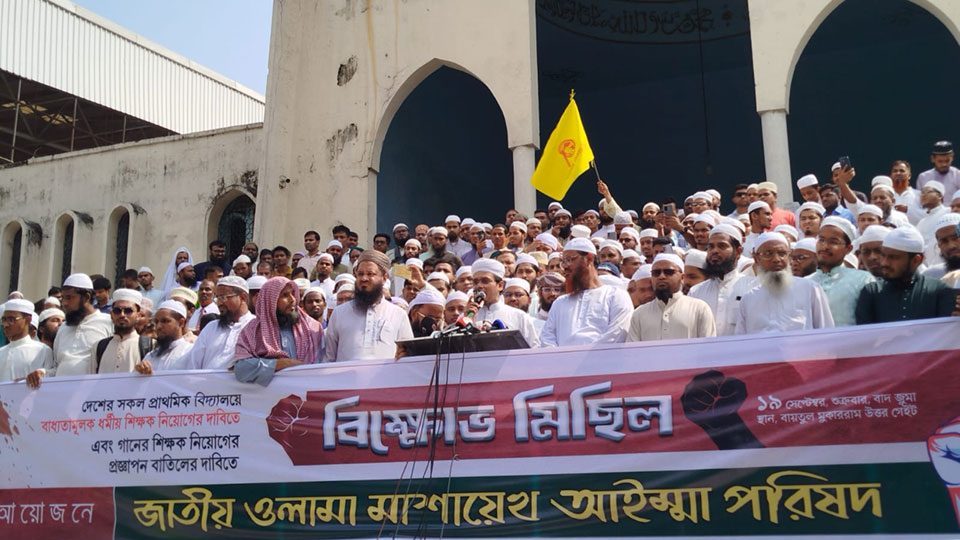 সরকারি প্রাথমিক বিদ্যালয়ে গানের শিক্ষক নিয়োগের সিদ্ধান্তের প্রতিবাদে ও ধর্মীয় শিক্ষক নিয়োগ দাবিতে গত শুক্রবার (১৯ সেপ্টেম্বর) জুমার নামাজ শেষে জাতীয় মসজিদ বায়তুল মোকাররমে থেকে জাতীয় ওলামা মাশায়েখ আইম্মা পরিষদের ব্যানারে বিক্ষোভ মিছিল করেন ওলামা মাশায়েখরা।
